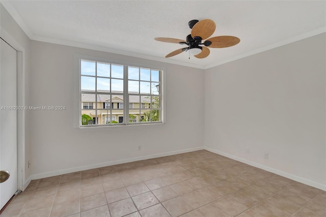 tiled spare room with ceiling fan and crown molding