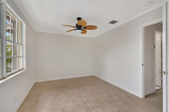 tiled spare room featuring ceiling fan and ornamental molding