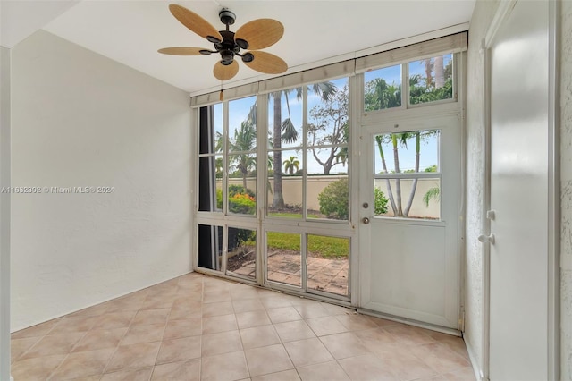 empty room with ceiling fan and light tile patterned floors