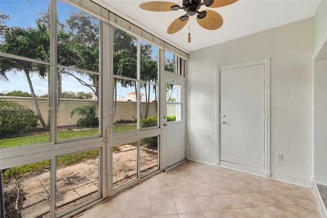 unfurnished sunroom featuring ceiling fan