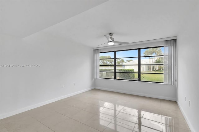 empty room with ceiling fan and light tile patterned floors