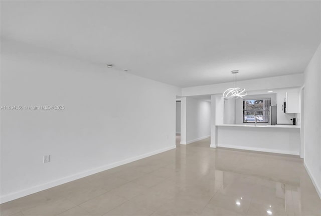 unfurnished living room featuring a notable chandelier