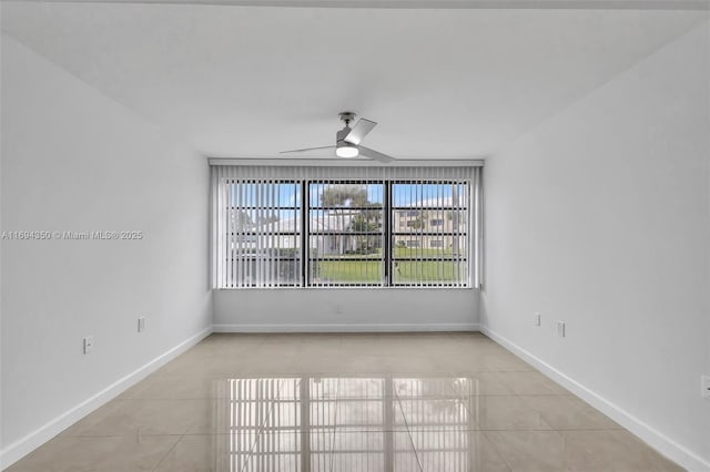 spare room with ceiling fan and light tile patterned floors