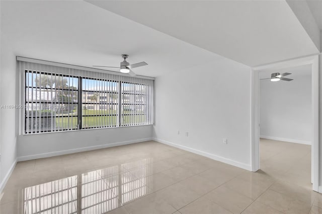 tiled spare room with ceiling fan