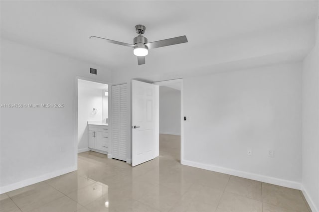 unfurnished bedroom featuring ceiling fan, connected bathroom, and light tile patterned floors