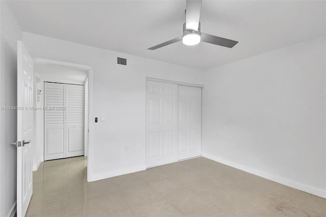 unfurnished bedroom with ceiling fan and a closet