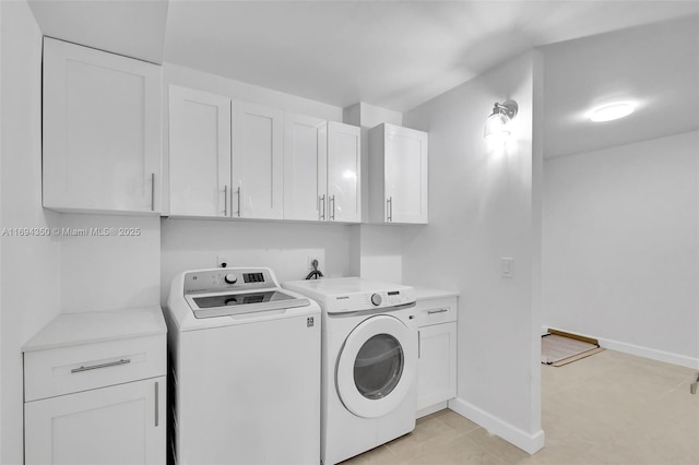 laundry area with washer and dryer and cabinets