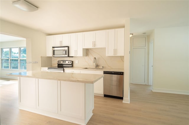 kitchen with white cabinetry, sink, stainless steel appliances, and light hardwood / wood-style flooring