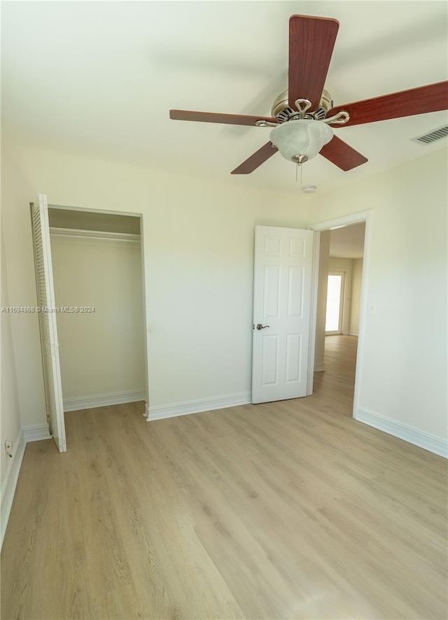 unfurnished bedroom featuring a closet, light hardwood / wood-style flooring, and ceiling fan