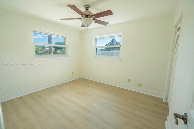 unfurnished bedroom with a closet, light hardwood / wood-style floors, multiple windows, and ceiling fan