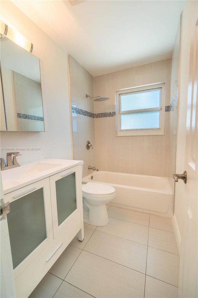 full bathroom featuring tile patterned flooring, vanity, tiled shower / bath combo, and toilet