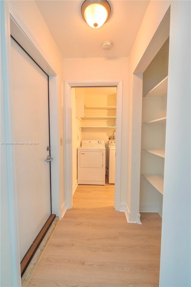 4450 SW 34th Dr, Dania Beach, FL 33312 - hallway featuring washing machine and clothes dryer, light wood-type flooring, and baseboards