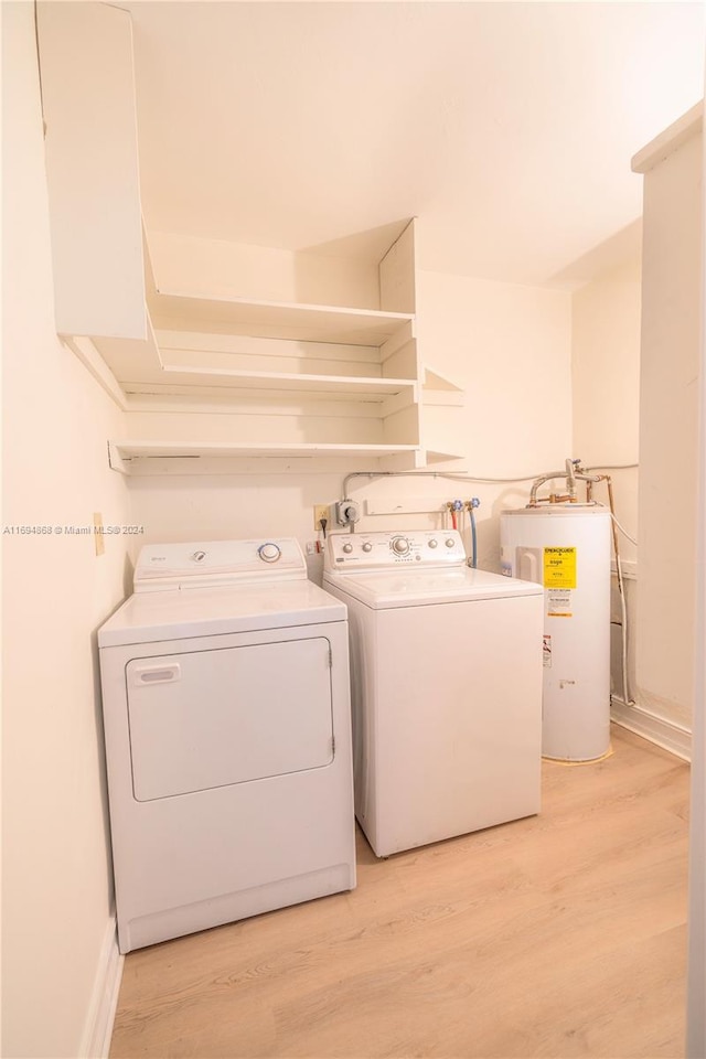 laundry room featuring electric water heater, washer and dryer, and light wood-type flooring