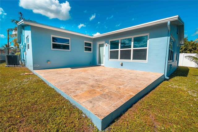 back of property featuring central AC unit, a yard, and a patio