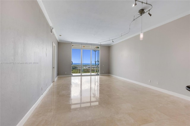 unfurnished room featuring expansive windows, crown molding, and track lighting