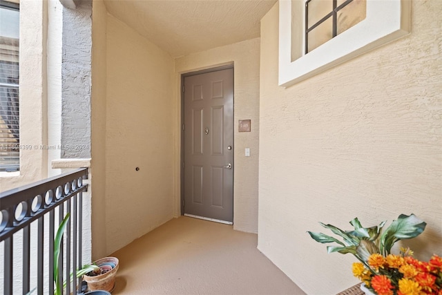 view of exterior entry with a balcony