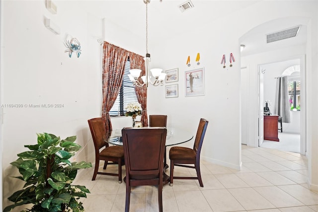 tiled dining area with a chandelier