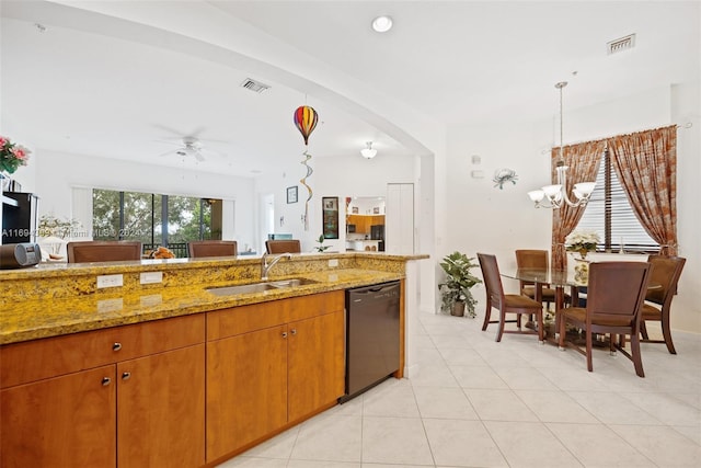 kitchen featuring light stone countertops, sink, hanging light fixtures, black dishwasher, and ceiling fan with notable chandelier