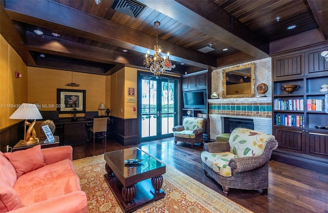 living room with beamed ceiling, a chandelier, dark wood-type flooring, and french doors