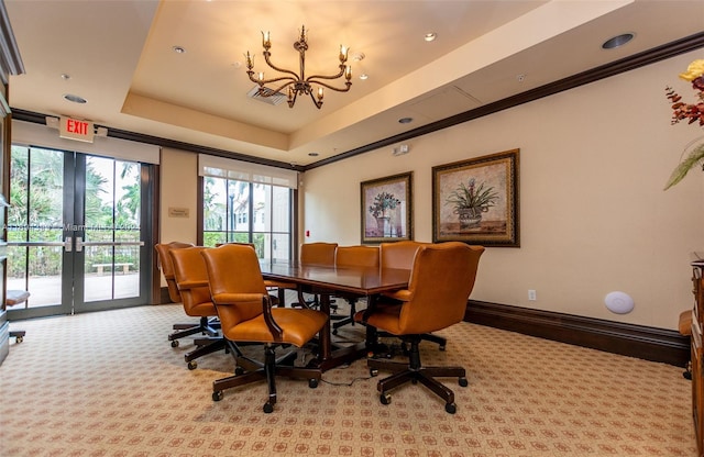 dining room featuring an inviting chandelier, light carpet, a tray ceiling, and french doors