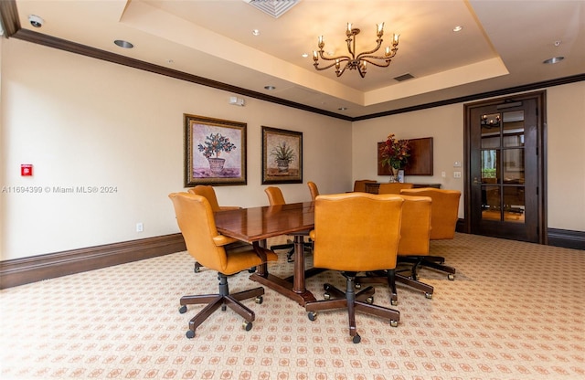 carpeted dining room featuring a raised ceiling, an inviting chandelier, and crown molding