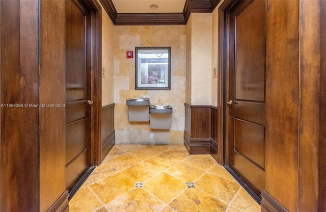 hall with ornamental molding and tile walls