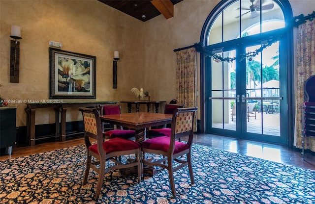 dining room featuring french doors, beamed ceiling, a high ceiling, and hardwood / wood-style flooring