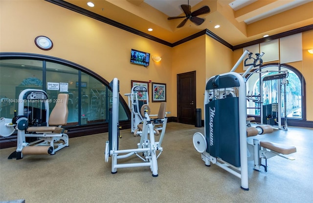 gym featuring a high ceiling, ceiling fan, and crown molding