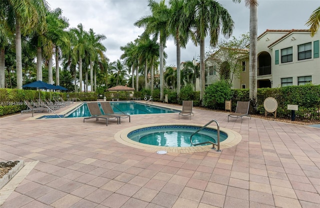 view of swimming pool featuring a patio area and a hot tub