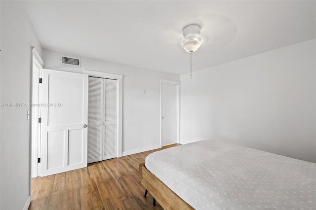 bedroom with wood-type flooring, a closet, and ceiling fan