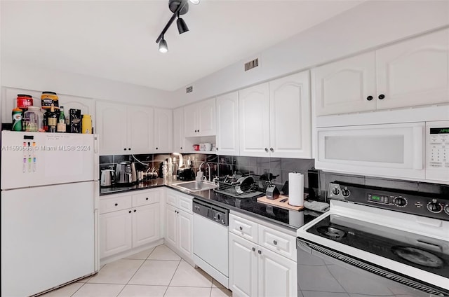 kitchen with white appliances, backsplash, white cabinets, sink, and light tile patterned floors