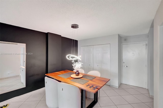 tiled dining space with a textured ceiling