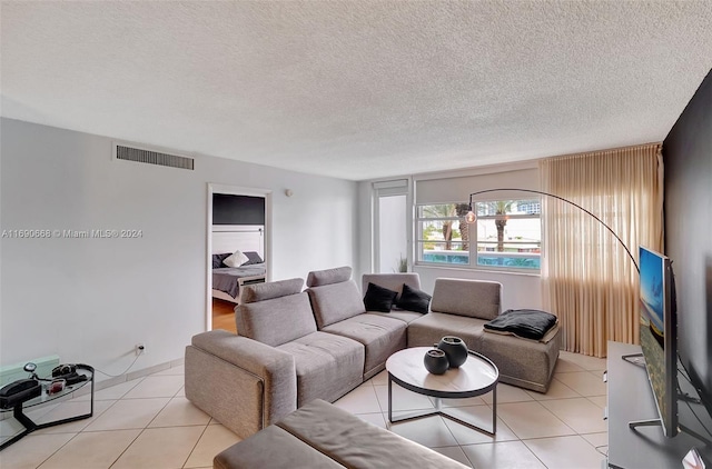 tiled living room featuring a textured ceiling