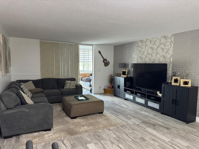 living room with a textured ceiling and light hardwood / wood-style floors