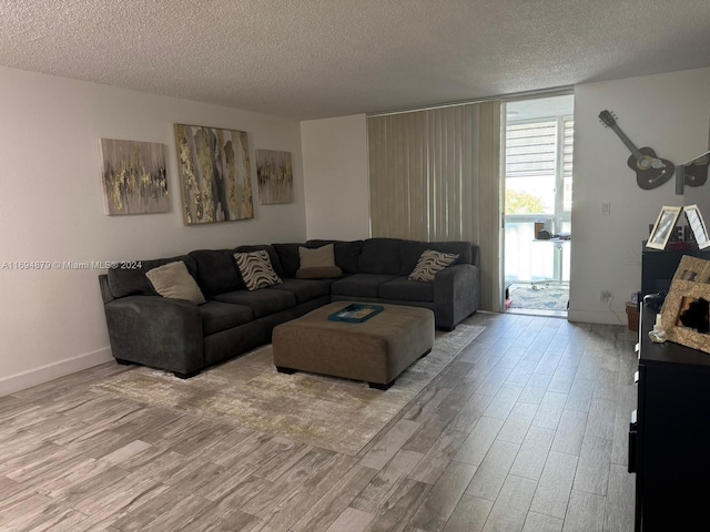 living room featuring light hardwood / wood-style floors and a textured ceiling