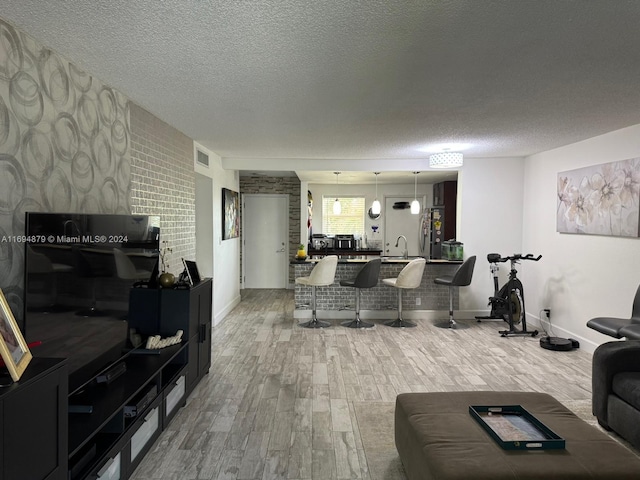 living room with hardwood / wood-style floors, sink, and a textured ceiling