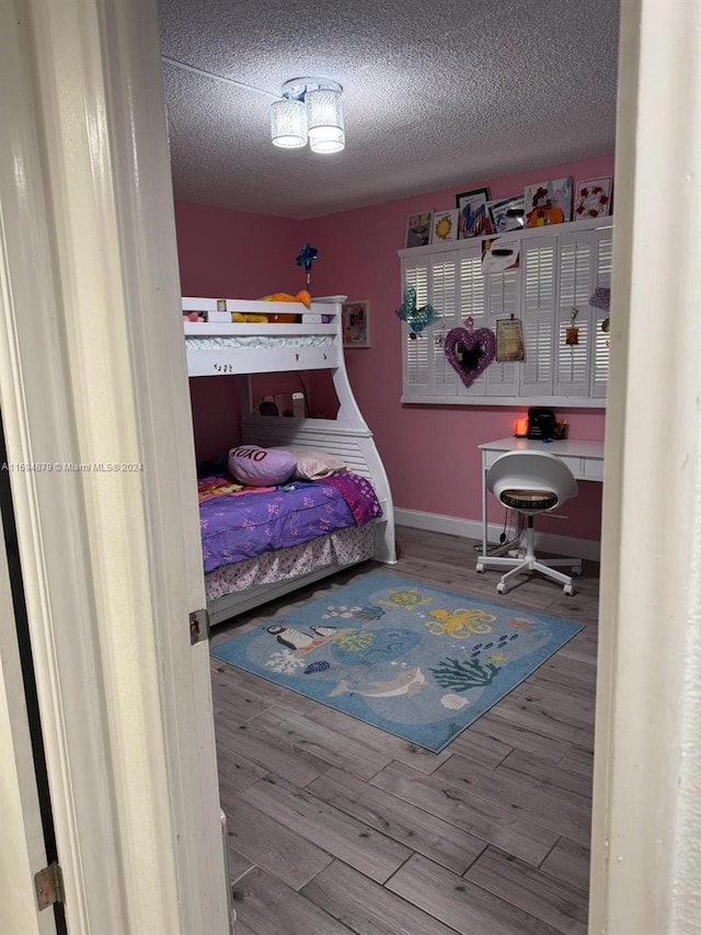 bedroom with a textured ceiling and hardwood / wood-style flooring