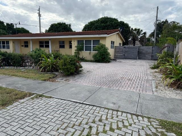 view of front facade with driveway, fence, a gate, and stucco siding