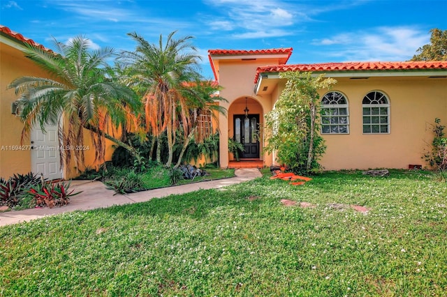 mediterranean / spanish-style home with a front lawn