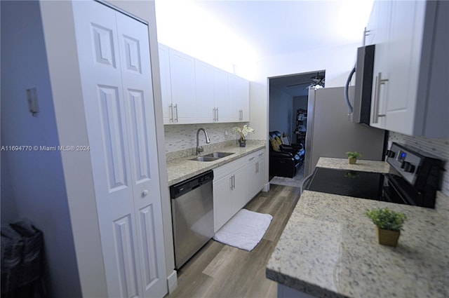 kitchen featuring white cabinets, appliances with stainless steel finishes, decorative backsplash, and sink