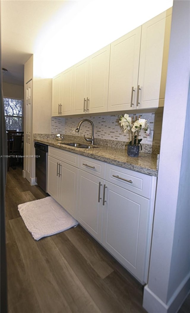 kitchen featuring tasteful backsplash, sink, dark hardwood / wood-style flooring, and black dishwasher