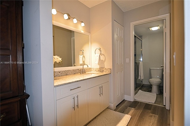 bathroom featuring toilet, vanity, and hardwood / wood-style flooring