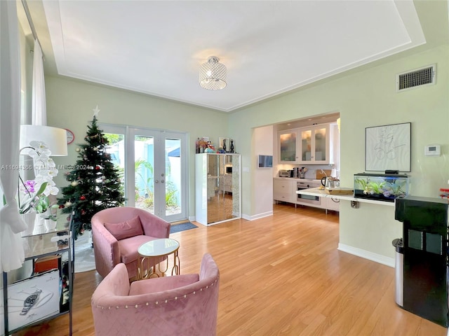 living area featuring french doors and light hardwood / wood-style flooring