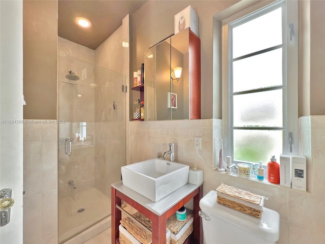 bathroom featuring toilet, a shower with door, sink, and tile walls