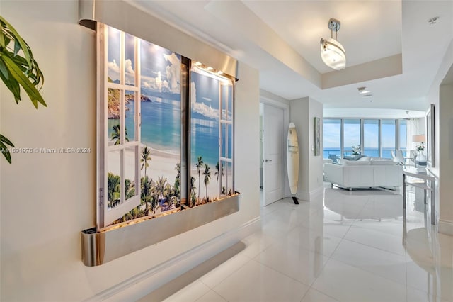 hallway featuring tile patterned flooring and a water view