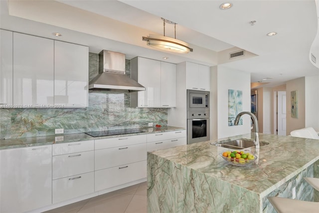 kitchen with white cabinetry, sink, wall chimney exhaust hood, tasteful backsplash, and appliances with stainless steel finishes