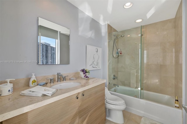 full bathroom with tile patterned floors, vanity, toilet, and bath / shower combo with glass door