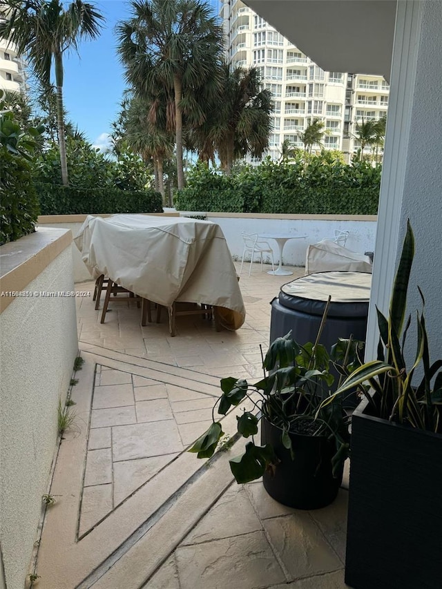 view of patio / terrace with area for grilling, a balcony, and a jacuzzi