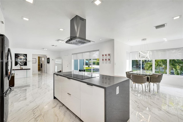 kitchen with white cabinetry, island range hood, decorative light fixtures, a kitchen island, and black appliances