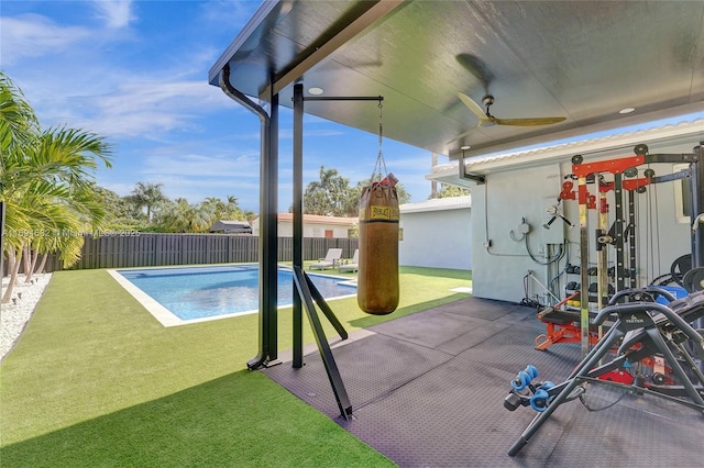 view of swimming pool with a patio area, ceiling fan, and a lawn